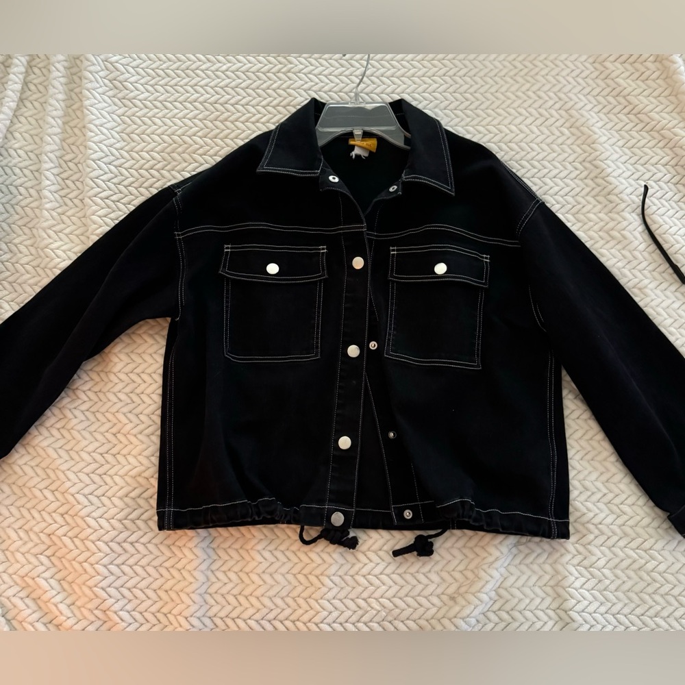 Black denim jacket with white stitching